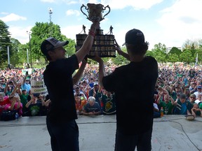 London Knights co-captains Mitch Marner, left, and Christian Dvorak raise the Memorial Cup to show thousands of fans who showed up to greet them in Victoria Park on Monday. (MORRIS LAMONT, The London Free Press)