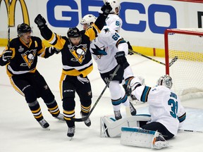 Penguins' Bryan Rust (centre) celebrates his goal against Sharks goalie Martin Jones (31) during first period action in Game 1 of the Stanley Cup final in Pittsburgh on Monday, May 30, 2016. (Gene J. Puskar/AP Photo)