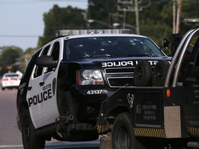A Houston Police Deptartment vehicle hit many times by gunfire is removed from the area Sunday, May 29, 2016, in Houston. A man came into a Houston auto detail shop and began shooting, killing a man known to be a customer and putting a neighborhood on lockdown before being killed by a SWAT officer, police said. Several people were shot and injured, (Elizabeth Conley/Houston Chronicle via AP)