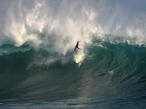 A surfer rides the waves in this Sept. 5, 2014 file photo. (MARK RALSTON/AFP/Getty Images)