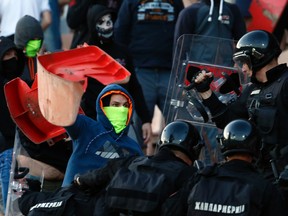 In this Saturday, April 16, 2016. file photo, Serbian riot police officers clash with Red Star fans during a Serbian league derby match between Red Star and Partizan, in Belgrade, Serbia. (AP Photo/Darko Vojinovic, File)