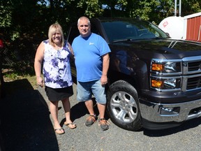 In this Sept. 17, 2015 photo, Joan Lechleitner and Kerry Titus, both of Pottsville, stand next to the 2015 Chevrolet Silverado 1500 Z71 the couple bought with money they won playing the Cash 5 lottery game in September 2015. The couple were charged Tuesday, May 31, 2016, along with two other former employees with stealing from the Agway store in Cressona that they bought the winning ticket from. (Nick Meyer/The Republican-Herald via AP)