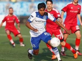 Edmonton's Shamit Shome, a graduate of the FC Edmonton youth academy, rushes with the ball through Fury defenders during a NASL game between FC Edmonton and the Ottawa Fury at Clarke Stadium in Edmonton on May 11. (Ian Kucerak)