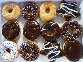 An assortment of ring doughnuts and filled doughnuts, glazed doughnuts and powdered doughnuts is seen in a paper box in Washington, DC June 5, 2015. The first Friday in June is "National Donut Day" in the United States. AFP PHOTO Eva HAMBACH