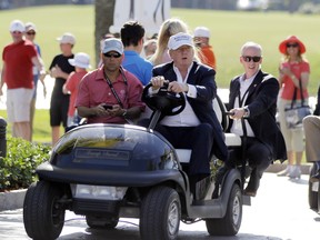 In this March 6, 2016, file photo, Republican presidential candidate Donald Trump, right, drives himself around the golf course to watch the final round of the Cadillac Championship golf tournament in Doral, Fla. Donald Trump is losing business to Mexico, a prestigious golf tournament at his resort at Doral. (AP Photo/Luis Alvarez, File)