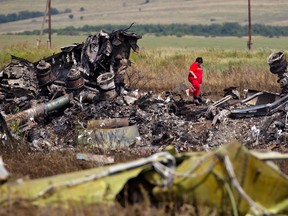 In this Sunday, July 20, 2014 file photo, a Ukrainian paramedic walks amongst charred debris at the crash site of Malaysia Airlines Flight 17 near the village of Hrabove, eastern Ukraine. (AP Photo/Vadim Ghirda, File)