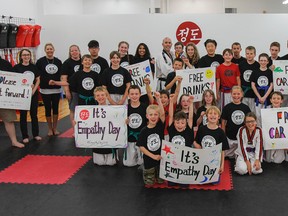 Students, parents and instructors at the Jung Do Martial Arts Academy show off their special signs and shirts that they used during the academy's annual Empathy Day. (Julia McKay/The Whig-Standard)