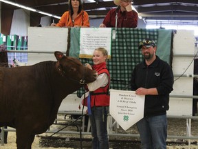 Grand Champion Erica Mackenzie with her steer, James, and a representative from the Pincher Creek Co-op, which purchased him for $5.20/lb.