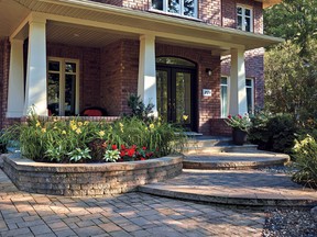 The homeowner uses stone products to create permanent flower beds leading up to their home. (www.permacon.ca).