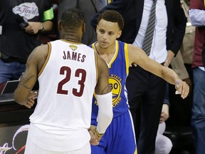 Cleveland Cavaliers forward LeBron James (23) hugs Golden State Warriors guard Stephen Curry (30) during the second half of Game 6 of basketball's NBA Finals in Cleveland June 16, 2015. (AP Photo/Darron Cummings, File)