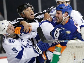 Linesman Jay Sharrers, middle, tries to break up a fight between Tampa Bay Lightning centre Tyler Johnson (9) and New York Islanders centre Casey Cizikas during Game 3 of the Eastern Conference semifinals Tuesday, May 3, 2016, in New York. (AP Photo/Frank Franklin II)