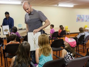 Dr. Jeffery Newton, programs director with the Alberta Science Network (ASN), and an ASN volunteer each carry a display of two types of stick insects, during a small crawling and flying animals presentation at the Vermilion Public Library on Wednesday, May 25. Taylor Hermiston/Vermilion Standard/Postmedia Network.
