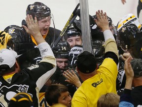 Pittsburgh Penguins' Conor Sheary is mobbed by teammates after his goal against the San Jose Sharks in overtime of Game 2 of the Stanley Cup finals in Pittsburgh on June 1, 2016. (AP Photo/Gene J. Puskar)