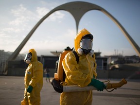 In this Tuesday, Jan. 26, 2016 file photo, health workers stands in the Sambadrome spraying insecticide to combat the mosquito that transmits the Zika virus in Rio de Janeiro, Brazil. (AP Photo/Leo Correa, File)