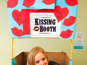 Nicole Lightowler, animal care staff member with the Kingston Humane Society, poses with a 2-month old Boxer-Lab mix puppy in the puppy kissing booth, in Kingston, Ont. on Thursday June 2, 2016, The booth, along with shelter tours and adoptions, will be among the variety of activities taking place during the Shelter Day event on Sunday, June 5. Julia McKay/The Whig-Standard/Postmedia Network