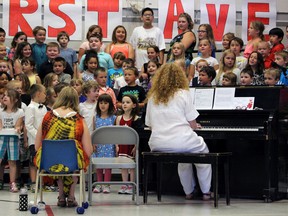 Principal Jan LeClair plays piano accompaniment along with a choir of her students at the closing ceremony in the First Avenue Public School gymnasium in Kingston on Friday. (Julia Balakrishnan/For The Whig-Standard)