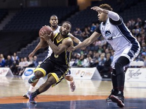 London Lightning's Akeem Scott, centre, drives between Halifax Hurricanes Cliff Clinkscales, left, and Mike Glover during first half NBL Canada playoff finals action in Halifax on Friday, June 3, 2016. THE CANADIAN PRESS/Darren Calabrese