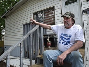 Glenn Dobson, on the front porch of his home, never left Fort McMurray as tens of thousands fled the massive wildfire