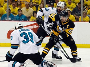 Pittsburgh Penguins' Sidney Crosby tries to pass against San Jose Sharks' Logan Couture and Patrick Marleau during the first period of Game 1 of the Stanley Cup final in Pittsburgh on May 30, 2016. (AP Photo/Keith Srakocic)