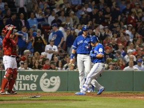 Devon Travis of the Toronto Blue Jays touches home plate after hitting a home run against the Boston Red Sox in the eighth inning on June 3, 2016 at Fenway Park in Boston, Mass. (DARREN McCOLLESTER/Getty Images/AFP)