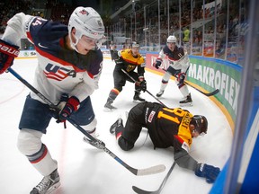 In this May 15, 2016 file photo, United States' Auston Matthews, left, fights for the puck with Germany’s Torsten Ankert during a Hockey World Championships Group B match in St.Petersburg, Russia. Matthews spent the past year playing in Switzerland, where he established himself as the NHL's top-ranked draft prospect. Matthews is from Arizona and among more than 100 draft-eligible players taking part in the league's rookie combine in Buffalo. (AP Photo/Dmitri Lovetsky, File)
