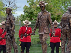 A bronze monument featuring life-size statues of Constables Doug Larche, Dave Ross and Fabrice Gevaudan, who were gunned down two years ago, is unveiled in Moncton, N.B., on Saturday, June 4, 2016. The monument was created by artist Morgan MacDonald. THE CANADIAN PRESS/Andrew Vaughan