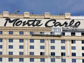 In this Feb. 13, 2008 file photo, workers install a new sign on the facade of the Monte Carlo Resort and Casino in Las Vegas. (AP Photo/Jae C. Hong, File)