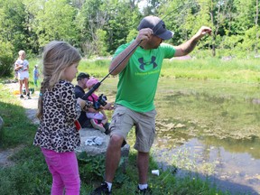 Three-year-old Stella Crane from Ingersoll reels in a fish with some help from her dad during the annual Rotary Fishing Derby at Smith's Pond. The Crane kids caught the first three fish of the day. (MEGAN STACEY/Sentinel-Review)