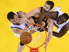 Cavaliers forward Kevin Love (centre) reaches for the ball between Warriors centre Andrew Bogut (left) and forward Draymond Green during Game 2. The Warriors and Cavaliers are back at it Sunday night for Game 2 in Oakland. (AP)