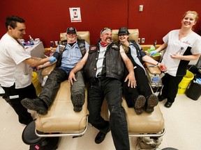 Tom Bottolfs of the Canadian Lonewolves Independent Riders, centre, gets in on the action as his wife, Lisa Bottolfs, and Ron Blackburn donate blood under the watchful eyes of phlebotomists Harlee Courtepatte and Lesley MacQueen at the Edmonton Blood Donor Clinic on Saturday, June 4, 2016.