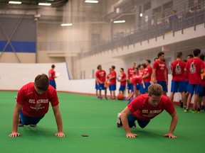 ayden Platz and Ethan Cap do pushups during the Edmonton Oil King's rookie fitness testing session at the Dow Centennial Centre in Fort Saskatchewan on August 27, 2015.