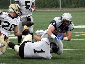 Sudbury Spartans running back Josh Cuomo is tackled as he rushes the ball during a Northern Football Conference game against the Tri-City Outlaws on Saturday. Ben Leeson/The Sudbury Star/Postmedia Network