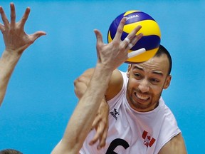Justin Duff of Canada spikes against France during their Men's Volleyball World Olympic qualification tournament match in Tokyo, Thursday, June 2, 2016. (AP Photo/Shizuo Kambayashi)