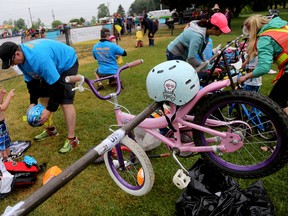 Volunteers help kids in the sub-midget three-to-five year old category transition between the swimming and cycling portion of their triathlon during the 10th annual County Kids of Steel competition on Sunday June 5, 2016 in Picton, Ont. Emily Mountney-Lessard/Belleville Intelligencer/Postmedia Network