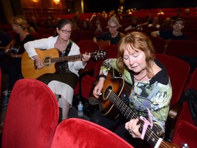 Linda Lucas, left, and Lynn Davis Bertie take part in a group rendition of Joni Mitchell?s Big Yellow Taxi at the Grand Theatre on Sunday.  (MORRIS LAMONT, The London Free Press)