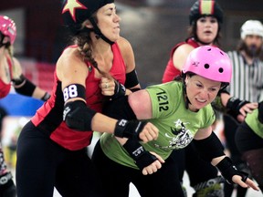 Tracey "T-Wrecks" Lalonde of the host Timmins Gold Miners' Daughters absorbs a hit courtesy of Josée "Princess Powerhouse" Leclair of the Sudbury Smelter Skelter at the Doom in June V roller derby event at the Archie Dillon Sportsplex Arena on Saturday. The Gold Miners' Daughters held off the Smelter Skelter's comeback for a 170-121 triumph. BENJAMIN AUBÉ/THE DAILY PRESS