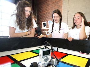 Grade 8 students Jessica Brock (left), Avery Anderson and Sadee Pridham, from Mitchell District High School, watch their Lego Mindstorms robot use its sensors to navigate and record colours during a challenge in D&D Automation's Awesome Battle of the Bots on Tuesday May 31 in Stratford.  MIKE BEITZ POSTMEDIA NETWORK