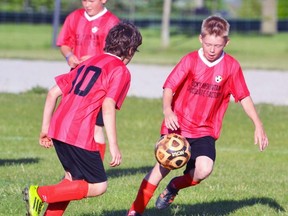 Kyle Mills and Caleb Kay (right) assist each other as they advance upfield during a Mitchell vs. Mitchell 11U soccer game at Upper Thames Elementary School (UTES) soccer field last Tuesday, May 31, a 3-3 tie. GALEN SIMMONS MITCHELL ADVOCATE