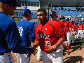 Josh Naylor and his teammates get congratulated after the Canadian junior team played the Toronto Blue Jays in Dunedin, Fla., March 15, 2015. (Stan Behal/Toronto Sun/Postmedia Network)