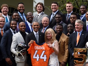President Barack Obama, centre, standing next to Annabel Bowlen, wife of Broncos owner Pat Bowlen, holds up a Denver Broncos team football jersey, as he welcomes the Super Bowl Champions during a ceremony in the Rose Garden of the White House in Washington, Monday, June 6, 2016, to honor the team and their Super Bowl 50 victory.(AP Photo/Susan Walsh)