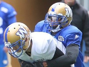 Winnipeg Blue Bombers defensive back Bruce Johnson (right) grabs wide receiver Rory Kohlert during practice on Monday. (Brian Donogh/Winnipeg Sun)