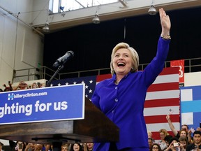 Democratic presidential candidate Hillary Clinton, left, reacts as she takes the stage at a rally, Monday, June 6, 2016, in Long Beach, Calif. Eight years after conceding she was unable to "shatter that highest, hardest glass ceiling," Clinton is embracing her place in history as she finally crashes through as the presumptive Democratic presidential nominee. (AP Photo/John Locher)