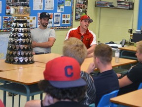 Guelph Gryphons linebacker and Yates Cup winner Andrew Graham, right, displays the highly-coveted trophy to the Parkside football team Friday afternoon. Graham played football at PCI for five years before moving on to post-secondary play.