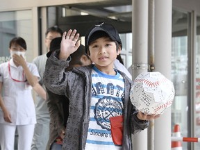 Yamato Tanooka, who was found after being abandoned by his parents as punishment in a forest, waves as he leaves a hospital in Hakodate on the northern island of Hokkaido on June 7, 2016. (Daisuke Suzuki/Kyodo News via AP)