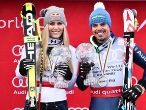 Lindsey Vonn of the US and Peter Fill of Italy pose after winning the overall downhill World Cup, in the finish area at the FIS Alpine Ski World Cup Finals, in St. Moritz, Switzerland, Wednesday, March 16, 2016. (Gian Ehrenzeller/Keystone via AP)