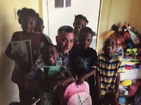 Gatineau Agent Pierre Lanthier with a group of children during his recent posting to Haiti. Supplied