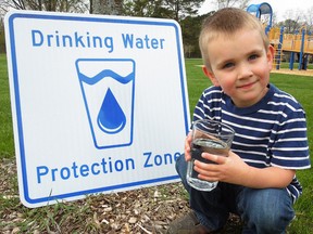 Iain vanKlinken poses with one of several signs going up around drinking water sources in Sarnia-Lambton. The awareness initiative is part of the area's water source protection plan. (Handout)