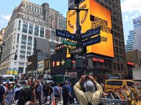 In this photo provided by New York City Hall, pedestrians photograph a street sign renaming West 33rd Street between 7th and 8th Avenues, "Muhammad Ali Way,"  Tuesday, June 7, 2016, in New York. (Michael Appleton/Mayoral Photography Office via AP)