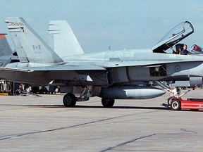 A Canadian Air Force CF-18 Hornet jet is towed along a runway on June 14, 2001. (Don MacKinnon/Getty Images)