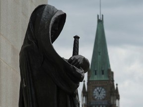 The Peace tower on Parliament Hill is seen behind the justice statue outside the Supreme Court of Canada in Ottawa, Monday June 6, 2016. The federal government will miss a deadline set by the Supreme Court for enacting a law in response to its ruling on physician-assisted death. THE CANADIAN PRESS/Adrian Wyld